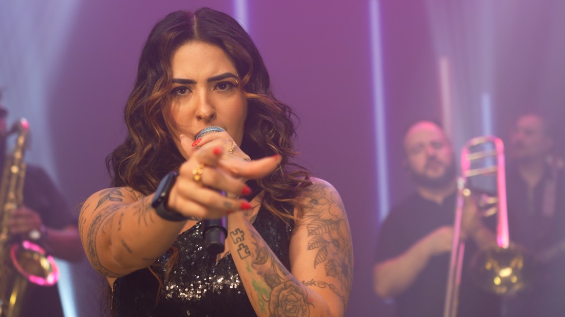 Vocalista da Banda Prime apontando o microfone para o público
