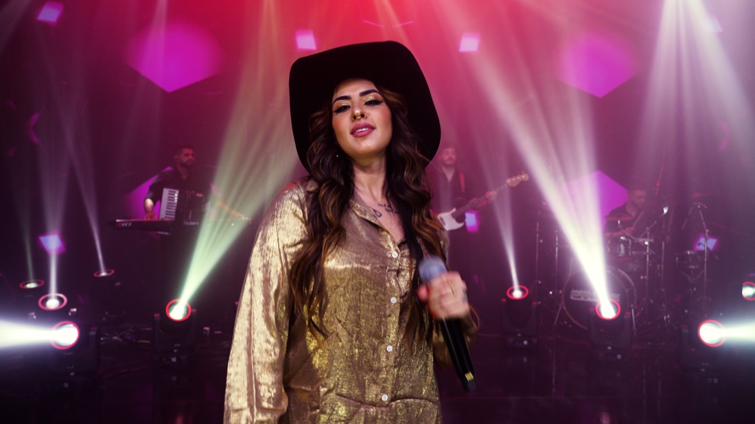 Vocalista da Banda Prime no palco com a banda ao fundo