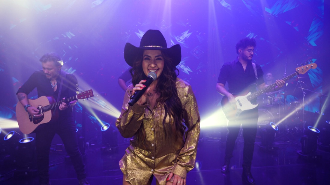 Vocalista da Banda Prime sorrindo com o violonista ao fundo